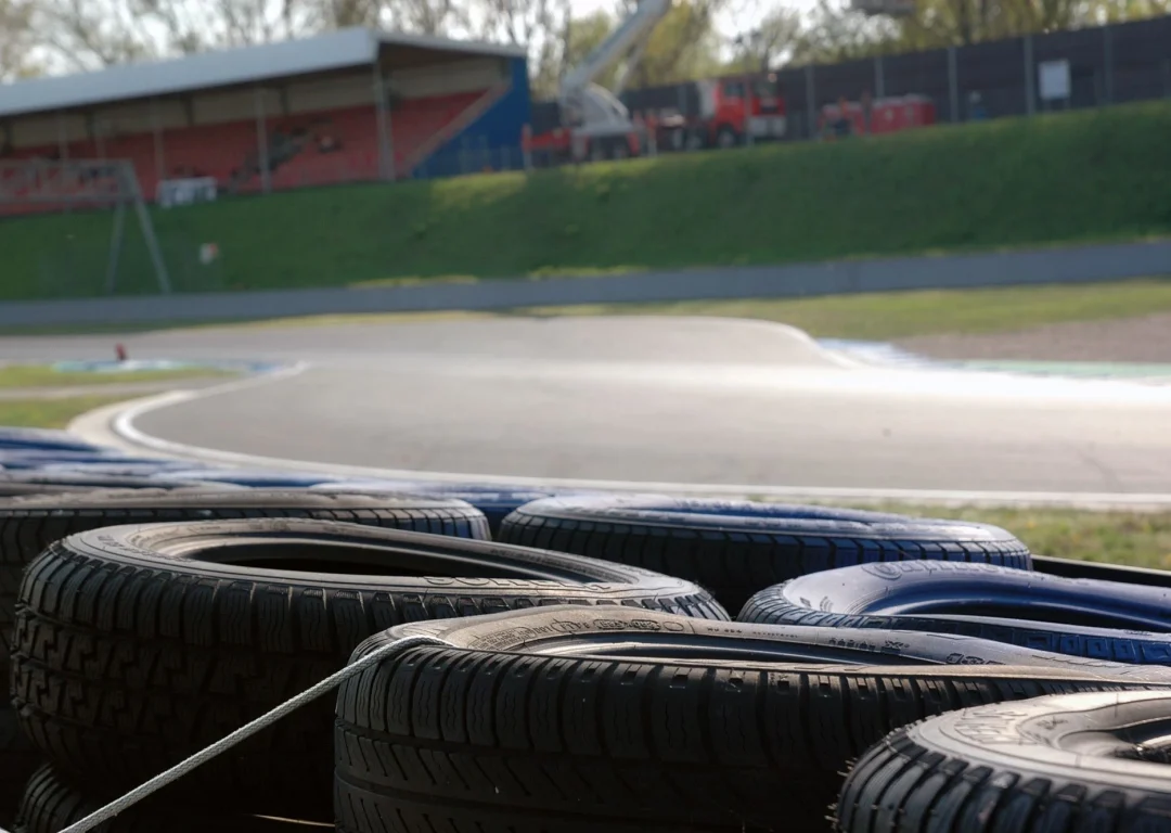 Close-up shot of trackside barriers made out of tyres with track in the background.