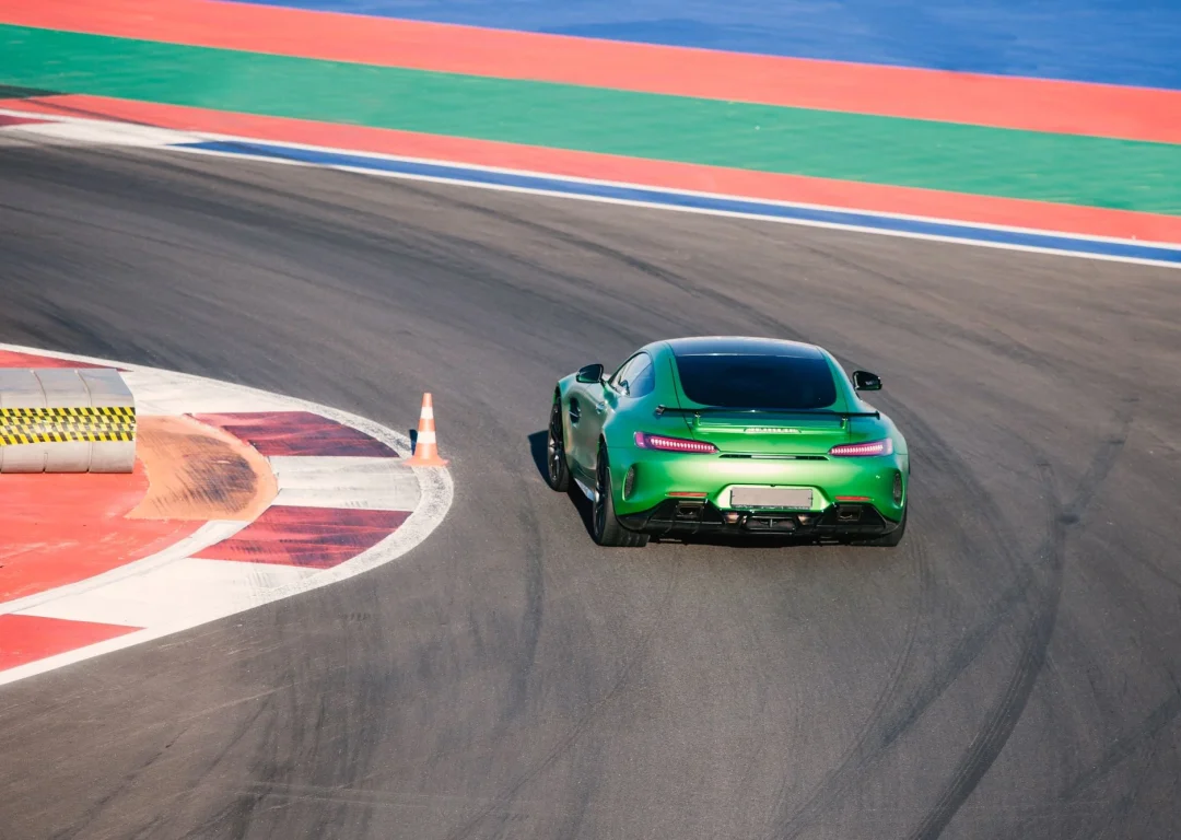 Aerial shot of a green sports car on a race track.
